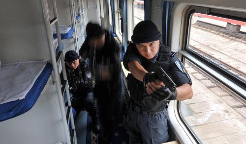 7月9日,重庆铁路公安处特警支队的一个战斗小组在列车的硬卧车厢进行战术综合训练。新华社记者 刘潺 摄