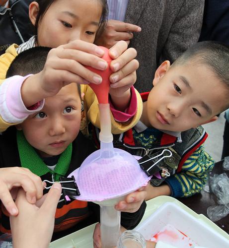 9月19日,在甘肃省平凉市举行的科普日大型宣传活动现场,孩子们动手参与“节约纸张,保护环境”科学调查体验活动。新华社发(杨昕 摄)