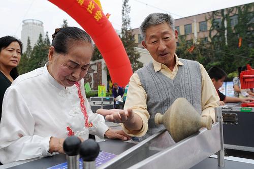 9月19日,两位老人在合肥和平广场举行的全国科普日宣传活动现场体验科普小装置,感受科技的魅力。新华社发(解琛 摄)