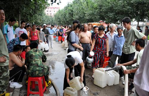 8月4日,临江市市民正在排队接水,消防部门用消防车运水解决饮用水困难。受7月31日降雨影响,吉林省临江市的2条供水管线在当天下午被冲断,造成临江市全城6.4万名居民供水中断,经过工作人员三天两宿的全力抢修,目前供水已经基本恢复,但水质尚未达到饮用标准,尚需1-3天才能正常饮用。临江市组织5台消防车,全天24小时免费定点供应饮用水,全力解决市民饮用水紧张问题。新华社记者 齐海山 摄