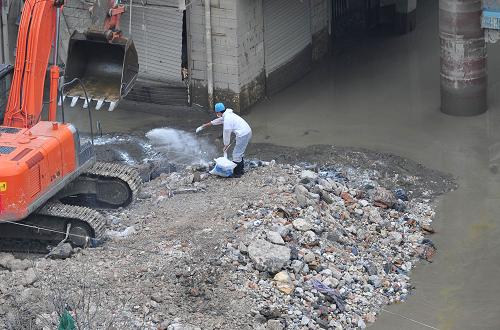 8月30日,在舟曲县城滨河商贸城外,防疫人员对水退后的街道和建筑物进行消毒。新华社记者 梁强 摄