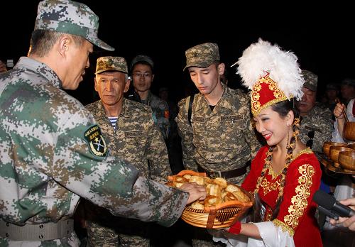 9月7日,“和平使命-2010”上海合作组织成员国武装力量联合反恐军事演习中方参演部队第一梯队官兵抵达哈萨克斯坦南部演习地域附近的奥塔尔车站,身着节日盛装的哈萨克斯坦姑娘向官兵们献上传统美食。新华社记者 王建民 摄