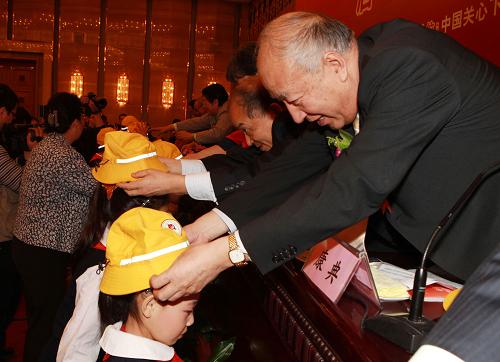 11月5日,组委会代表为小学生戴上交通安全标志帽。当日,由中国关心下一代工作委员会主办的“全国中小学生交通安全教育活动”在北京举行启动仪式。该项活动将在全国范围内推广佩戴新型小黄帽——“交通安全标志帽”,并引进新华保险承保“全国中小学生交通安全意外险”构建绿色救助通道,以及开展交通安全知识巡展、巡讲和“关爱孩子平安出行 万名驾驶员爱心签名”等形式活动。新华社记者 袁满 摄