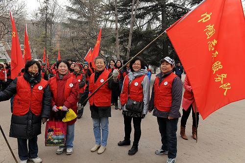3月1日,几位巾帼志愿者在启动仪式上展示巾帼志愿者服务队队旗。 当日,全国妇联“践行雷锋精神·百万巾帼志愿者在行动” 活动在北京启动,31个省区市妇联在各地也同时启动此活动。全国妇联号召百万巾帼志愿者立足社区,从身边做起、热情帮扶困难家庭,重点关爱留守妇女儿童、贫困单身母亲和空巢老人,积极开展法律宣传咨询、情感关怀抚慰、科学教育子女、社会环境保护等活动,推动学雷锋活动常态化,让雷锋精神在巾帼志愿服务实践中发扬光大。 新华社记者 何俊昌 摄