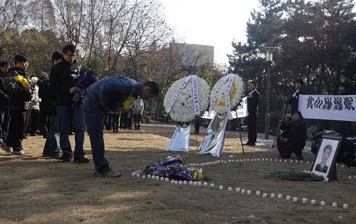 12月17日,一名获救学生在张宁海烈士遗像前鞠躬。 当日,复旦大学燕园挽钟哀鸣,300多名复旦大学的学生和校友举行悼念活动,沉痛追思为营救黄山被困学生而牺牲的张宁海烈士。 12月10日,由复旦大学10名在校生、4名校友与4名校外人员自发组成的“驴友”团来到黄山登山探险,随后迷路,被困悬崖边。13日,经黄山市警方及时营救,被困“驴友”脱险,而年仅24岁的黄山市公安局温泉派出所民警张宁海在搜寻中不幸牺牲。 新华社记者刘颖摄
