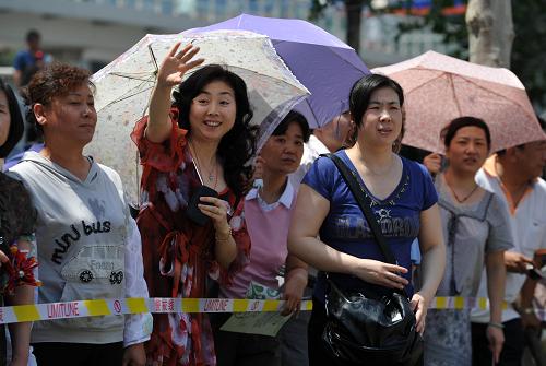 6月7日,在天津市第二南开中学考点,一名母亲向走出考场的考生招手。 当日是2011年全国高考第一天,共有约933万名考生报名参加考试。其中,应届普通高中毕业生报名人数与去年基本持平,往届生报名较去年减幅15%。普通高校招生计划675万名,平均录取率约为72.3%。 新华社记者 岳月伟 摄