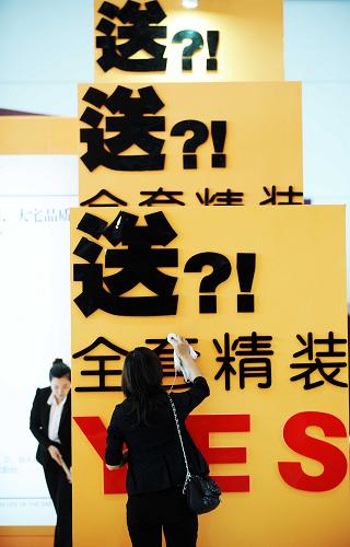 9月16日,哈尔滨一名房地产企业的工作人员在擦拭广告宣传语。 2011年,我国房地产市场有两个关键词——“限购”与“保障房”。在政府有力的楼市调控之下,不断高企的房价终于有所收敛,部分城市房价开始回调。与此同时,千万套保障房开工建设,让许多人的“住房梦”不再遥不可及。 年初召开的国务院常务会议确定从八个方面对房地产市场进行全面调控,以“限购”为龙头,“限价”“限贷”相辅相成的三项杀手锏成为贯穿全年的房地产调控基调。房价快速上涨的势头初步得到遏制,房地产市场逐渐显现成交量和成交价格双双下行的局面,整体呈稳中有降的情形。 与楼市调控一样,保障房的建设同样牵动人心。截至10月底,全国开工建设保障房超过1000万套,比原计划提前1个月完成目标任务。从数字、图纸到一幢幢拔地而起的楼房,保障性安居工程正按照计划推进。 中国社会科学院12月9日发布的《住房绿皮书:中国住房发展报告(2011~2012)》指出,房地产调控政策成效初显,民生导向有所突出。2010年以来,中央政府出台了一系列不断升级的房地产调控措施,直接影响到楼市的消费预期、购买行为、成交量乃至行