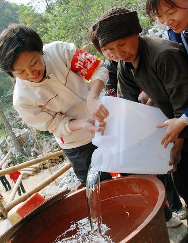 3月26日,广西河池市巾帼抗旱救灾服务队在东兰县隘洞镇板开村为孤寡老人韦乜练送水。新华社发(刘廷智 摄)