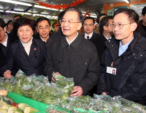 1月30日,中共中央政治局常委、国务院总理温家宝冒雨考察广东省市场供应工作。这是温家宝在广州东川新街市农贸市场考察。新华社记者姚大伟摄