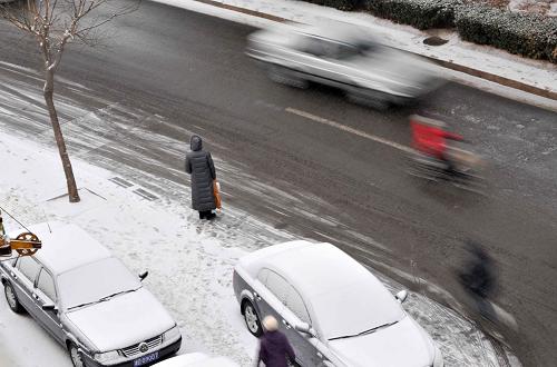 2月10日,一位市民站在雪中等车。当日,天津迎来兔年首场大范围降雪,气温明显降低。新华社记者 岳月伟 摄