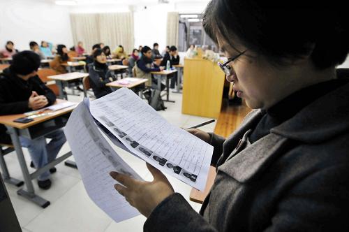 1月9日,广东外语外贸大学考点的一位监考老师在查看考生信息。 当日,2010年全国硕士研究生入学考试开考。据悉,2010年,全国硕士研究生报考人数达到140万人,较2009年增加13%。 新华社记者 陈晔华 摄