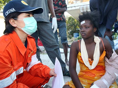 1月20日,在海地首都太子港,中国国际救援队队员曹力为在地震中失去两位亲人的一名妇女进行心理干预治疗。新华社记者 袁满 摄