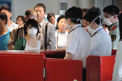 5月15日,入境旅客在出口处接受二次测温,并重新核对查看《健康申明表》。当日,南京市在禄口国际机场举行一场甲型H1N1流感应急处置演练,检验了检验检疫系统和卫生专业机构的综合应对能力。新华社记者 朱旭东 摄
