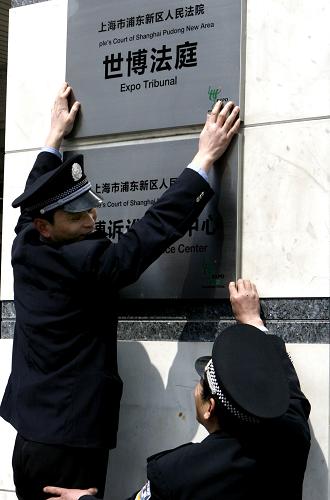 3月25日,法院工作人员正在悬挂“世博法庭”的牌子。新华社记者 陈飞 摄