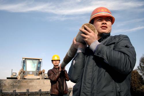 2月16日,两位工人正在国道211线A8合同段的建设工地上搬运护栏。2011年宁夏交通建设领域计划使用农民工两万人。据了解,今年宁夏将优先安排本地农民工就业,合理地提高农民工工资,同时加大农民工技能培训投入,提高他们的就业竞争能力。新华社记者 彭昭之 摄
