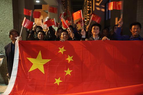 3月3日晚,在约旦首都安曼阿利娅王后国际机场,等待出发的中国工人手举国旗。 新华社发(穆罕默德·阿布古什摄)