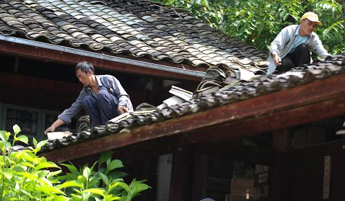 8月11日,村民帮助受灾最严重的芒棒镇郑山完小修葺房屋瓦片。云南腾冲“8·9”地震发生后,当地部分学校房屋和教学设施受到不同程度的破坏,随着新学年即将到来,受损较为严重的学校加快了校舍的加固和修复工作,确保学生能按时进入新学年上课。新华社记者 秦晴 摄