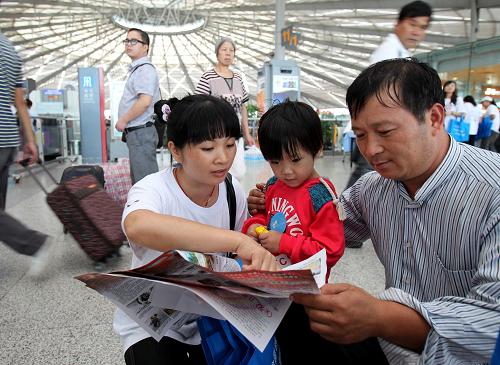 8月25日,在上海南站候车大厅内,防拐志愿者万光碧(左)向来自湖南的旅客张先生宣传防拐、儿童安全等常识。当日,上海市妇联、上海市公安局和上海市铁路局联合,在流动人口集中的上海南站、上海火车站,开展以“预防拐卖、安全流动、安全就业”为主题的暑期防拐宣传活动。除了发放宣传品外,20多名志愿者及工作人员和公众进行面对面交流,宣传防拐常识,引起公众对拐卖妇女儿童问题的关注。新华社记者 刘颖 摄
