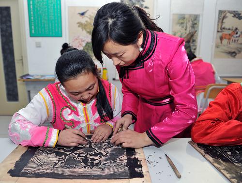 11月21日,美术老师赵美英在版画课上辅导学生。内蒙古自治区通辽市生活着152万科尔沁蒙古族同胞。多年来,通辽市在学校建设方面提倡特色办学、特色立校。通辽蒙古族中学则在这方面探索出一条深受蒙古族群众欢迎的路子。学校在努力抓好教学质量,并在科技创新、高考升学等方面下功夫。在学校课程中开设了蒙古族历史文化、科尔沁刺绣、科尔沁文化欣赏、科尔沁版画等多门本地化课程,使特色教育呈现出有声有色的局面。新华社记者 阿斯钢 摄
