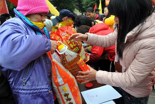 1月21日,广西柳州秀山社区的困难残疾人在春节慰问活动上喜领慰问品。新华社发(赖柳生 摄)
