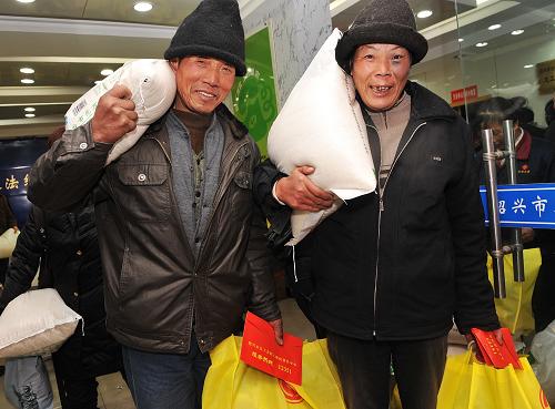 临近春节,绍兴市总工会筹集1200余万元,慰问困难职工、失业工人和外来务工者。图为绍兴市两名困难职工开心地领取价值300元的年货和1200元慰问金后回家。新华社发(袁云 摄)