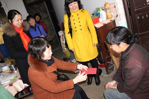1月21日,福建省顺昌县双溪街道棋盘居委会开展“送温暖 迎春节”活动,为遭受洪灾的困难居民送上慰问金。新华社发(陈柏材 摄)