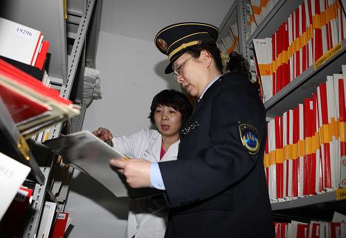 3月7日,卫生监督执法人员(右)在北京市朝阳区一家美容院内检查病案。新华社发(李方宇 摄)