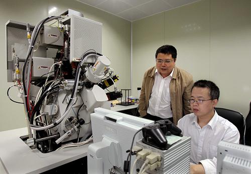 4月20日,中国科学院上海微系统与信息技术研究所研究员、PCRAM研究项目负责人宋志棠(左)与研究人员在实验室内工作。新华社记者 刘颖 摄