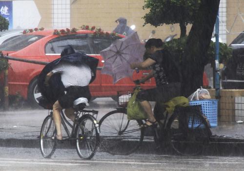 6月11日上午,广东汕头街头,两名居民顶风冒雨艰难骑车出行。 今年第3号热带风暴“莎莉嘉”于6月11日早晨5时45分在广东汕头市濠江区沿海地区登陆,登陆时中心附近最大风力8级。 广东省气象台预计,“莎莉嘉”登陆后继续向偏北方向移动,强度将迅速减弱。受“莎莉嘉”影响,11日粤东沿海和陆地有5至7级大风,汕头、梅州、揭阳、潮州等地市仍有大到暴雨。 新华社发(姚军 摄)