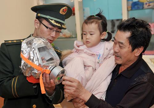 11月15日,重庆市荣昌县消防大队的一名消防战士在一高层建筑居民家中向住户讲解消防知识,传授防烟面罩使用技巧。当日,为增强高层住户的防火意识,提高火灾发生时的自救能力,重庆市荣昌县消防大队针对辖区80多栋高层建筑启动了“珍爱生命,从我做起”消防安全宣传活动。消防战士们深入到高层住户家中、居民社区、幼儿园等地,开展消防宣传,并向高层住户们无偿发放了2500多具防烟面罩。据了解,防烟面罩可有效防止浓烟对人体的危害,将普通人在火灾浓烟熏蒸下的生存时间提高到40分钟。新华社记者 刘潺 摄