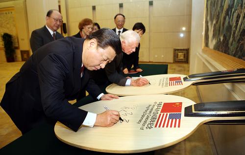 12月8日,中国人民对外友好协会和国家体育总局在北京人民大会堂举行中美“乒乓外交”四十周年纪念活动。国家副主席习近平、美国前总统卡特共同出席并致辞。这是习近平和卡特共同在中美“乒乓外交”四十周年纪念球拍上签名留念。 新华社记者 姚大伟 摄