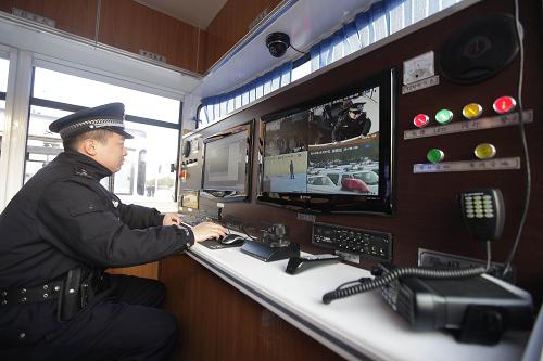 12月9日,湖北武汉一名民警在“萌版”治安卡点车里工作。 当日,武汉警方装备的107辆治安卡点车正式投入使用。其中有“萌版”治安卡点车17辆,分配在一类治安卡口;另有90辆“普通版”治安卡点车分配在二类治安卡口;其他三类治安卡口由普通警车负责备勤。 此次亮相的17辆“萌版”治安卡点车是大身配小轮,“前脸”看上去像公交车,车身有敬礼的卡通女警形象,车顶有4只能旋转的摄像头,造型可爱。据了解,这种“萌版”治安卡点车装备了视频监控、GPS、车载电台、无线上网本等设备,功能强大。 新华社发