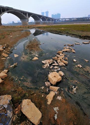长沙湘江橘子洲大桥附近一处污水排放口的污水已经将干涸的河床冲刷出一条沟壑(1月6日摄)。新华社记者 龙弘涛 摄