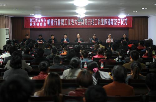 浙江温岭市新河镇南鉴村帽业行业的工资集体协商签字仪式现场(4月9日摄)。 4月9日,浙江温岭市新河镇南鉴村举行第五轮帽业行业工资集体协商签字仪式,106名参会职工代表共同见证。根据协议,代表8000多名工人的南鉴帽业行业工会与代表380多名企业主的南鉴帽业行业商会,最终就本年度工价平均上涨10%达成共识。南鉴是温岭的制帽特色村,2011年帽业产值约12亿元。 早在2003年,温岭市新河镇的羊毛衫行业在全国率先探索工资集体协商,2008年起帽业行业开展工资集体协商。据介绍,新河镇工资集体协商先是行业工会分别与企业主、员工“背靠背”谈;再由行业协会、行业工会分别代表企业主、工人“面对面”谈;经当地劳动部门认可后“拍板”。通过集体协商,工资由工人、企业主和行业组织公开“谈判”决定,而不是企业主单方“定价”,能够有效化解日益增多的劳资矛盾,实现政府、企业、员工“多赢”的局面。 “劳工大省”浙江正在广泛推进工资集体协商制度,不仅规模民营企业普遍建立了工资协商共决制度,大量中小民营企业还开展了区域性、行业性工资集体协商。截至2011年底,浙江省共签订工资协议9.27