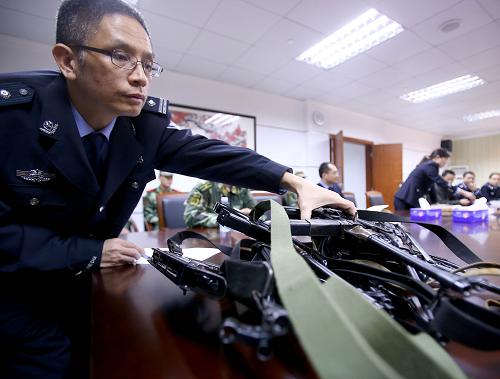 深圳缉私局文锦渡分局缉私警察在“GS01”行动前分发枪支(3月26日摄)。 3月26日凌晨,在海关总署组织协调下,深圳海关组织开展代号为“GS01”的“国门之盾”大规模查缉行动。此次行动以深圳为主战场,全国30余个大中城市同步联动,数百名缉私人员分为67个行动小组,在深圳、北京、广州、成都同时开展抓捕查缉行动,一举摧毁了一个涉案价值超过5亿元的电子产品走私集团,抓获涉案嫌疑人104名,刑事拘留涉嫌走私人员68人,现场查扣电子产品4800余件。该团伙主要在香港购货收货,利用“水客”采取“蚂蚁搬家”的方式走私iPhone手机等电子产品。 新华社记者陈建力摄