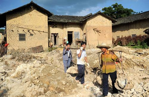 赣州市于都县葛坳乡小源村村民在土坯房前打地基准备盖新房子(7月1日摄)。 “终于可以住上‘新屋子’嘞!”江西省赣州市兴国县枫边乡山阳寨新屋组农民欧阳美萱将告别有着200多年历史的土坯房,搬进新居。他带着记者参观政府补贴新建的砖瓦房,欢喜得合不拢嘴。欧阳美萱家是山阳寨第一户享受政府援建补贴的农民。 为加大对赣南苏区农村土坯房改造的扶持力度,日前出台的《国务院关于支持赣南等原中央苏区振兴发展的若干意见》提出,到2015年,赣南等原中央苏区在解决突出的民生问题上取得突破性进展,尽快完成赣州市农村危旧土坯房改造任务。 80年前,山阳寨曾是中央苏区红军医院第二分院第四所驻地。在第一次和第三次反围剿中,淳朴的老乡腾出屋子,收治伤员,最多时每户收治伤员10多人。然而由于人均耕地少,地理位置偏,发展滞后,当前群众生活依然贫困,58户居民中仍有56户居住在有一两百年历史的土坯房内。统计显示,截至2011年底,赣州18个县(市、区)仍有60多万户农民居住在土坯房里,占农村总户数的40.6%。 据了解,为支持赣州土坯房改造,中央财政将在原来农村危房改造计划外额外安排