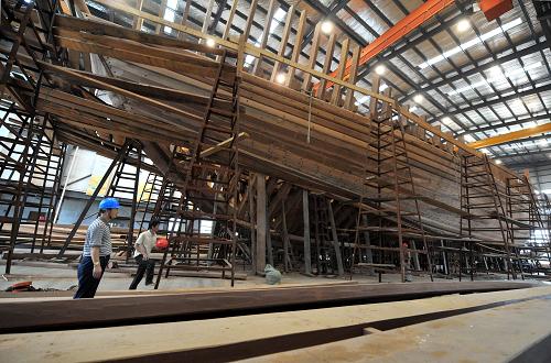 7月3日,明代宝船厂遗址上的复建厂房内,宝船复建施工正在进行中。 近日,南京“郑和宝船”复建工程取得重要进展。在位于明代宝船厂遗址上的复建厂房内,庞大的宝船主船体结构基本建成,即将转入底板和甲板铺设、设备定货、桅杆风帆设计及仿古装修等工程阶段。7月11日,南京作为2012中国航海日活动主会场,这艘初显雏形的“仿明代郑和宝船”将接受各地来宾的参观考察。 复建中的“郑和宝船”是以各种史料为依据,按等比例、全木质结构、可进行远洋航行的要求设计建造的。宝船由造木船世家传人组成的工匠队伍、采用传统的木船建造工艺建造。据介绍,为适应现代航海要求,宝船也将装备各种现代化的高科技先进设备。 按复建计划,这艘“仿明代郑和宝船”将于今年底完成主体设备安装,2014年下水,在试航成功后,开启“八下西洋”海上之旅。 新华社记者孙参摄