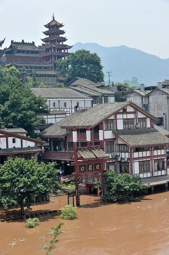 重庆嘉陵江洪峰过境 千年古镇变水城 7月6日,磁器口古镇的标志性建筑之一的磁器口大牌坊已经被洪水淹没过半。 当日,嘉陵江今年截至目前最大的洪峰通过重庆主城区,在朝天门汇入长江。洪峰的抵达使流经重庆主城区的嘉陵江水暴涨近3米,嘉陵江畔的千年古镇磁器口变身“水城”。300余户磁器口的商家在当地政府组织下有序撤离,一排排明清建筑风格的商铺浸泡在江水中,只露出青瓦顶,大量避险趸船只能将临时人行通道直接搭在临江商铺的屋顶上。据设在磁器口的嘉陵江临时水文监测点监测显示,磁器口嘉陵江水位在当日上午11时达到了183.85米,至下午14时开始逐步减退,预计嘉陵江今天至后天水位将可能陡退12.58米。 新华社记者 刘潺 摄