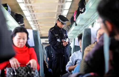 1月30日,裴亮在T112次列车上核查旅客身份。今年40岁的裴亮是杭州至兰州的T112次列车乘警长。今年春运是他参与的第14个春运。“算了一下,平均每年春运要跑4万公里,过春节时大多不能和家人在一起。”裴亮说。T112次列车从浙江杭州始发,经过安徽、江苏、河南、陕西等省份,最后到达甘肃兰州,行程约2400公里。新华社记者 韩传号 摄