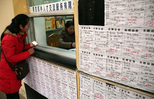 2月8日,求职农民工在职介机构服务窗口前咨询。新华社发(王新 摄)