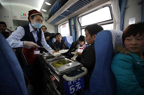 2月8日,乘务员在成都开往上海的K292次列车上,为乘客提供5元便民餐。成都铁路局在开行的普通列车上推出5元便民餐,解决农民工旅客吃饭的后顾之忧,让他们吃饱吃好。全面做好设备检查维修和人员准备,重点强化安全检查、售票组织、进出站疏导等工作,确保铁路春运安全有序。新华社记者 邢广利 摄