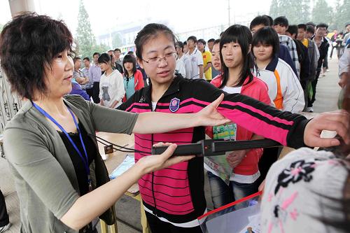 6月7日,在江苏省赣榆县高级中学考点,监考人员用金属探查仪对进入考场的考生进行检查。当日是2011年全国高考第一天,全国各地共有约933万名考生报名参加考试。各地精心组织,做好服务,同时采取切实措施,确保高考安全平稳顺利举行。新华社发(司伟 摄)