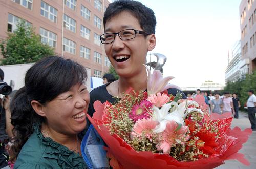 6月8日,在北京八中考点,考生宋晓考完最后一科走出考场后收到妈妈送上的鲜花。当日,全国部分地区2011年高考结束。今年全国共有高考考生933万人,比2008年减少117万,录取率提高至72.3%。新华社记者 赵琬微 摄