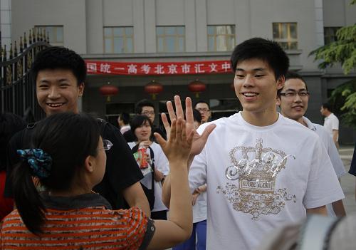 6月8日,在北京汇文中学考场外,一位考生在结束考试后与亲友击掌庆祝。新华社记者 邢广利 摄