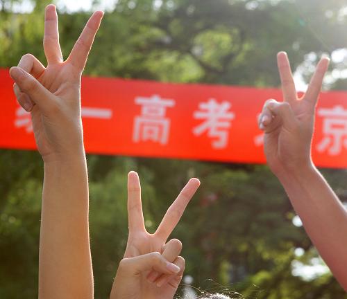 6月8日,在北京市第五十中学考点,考生们在结束最后一场考试后举起了代表成功的手势。新华社发(万象 摄)
