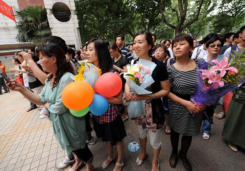 6月9日,亲友在南京市人民中学考点大门旁等候即将出考场的考生。新华社记者孙参摄