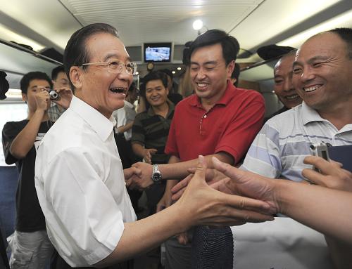 这是温家宝总理与乘客在一起。 6月30日,京沪高速铁路全线建成通车,国务院总理温家宝出席通车运营仪式并乘首发列车考察运营情况。 新华社记者 马占成 摄
