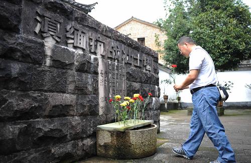 8月12日,一位游客在腾冲和顺古镇滇西抗战博物馆内参观,为滇缅抗战牺牲烈士献花。新华社记者 秦晴 摄