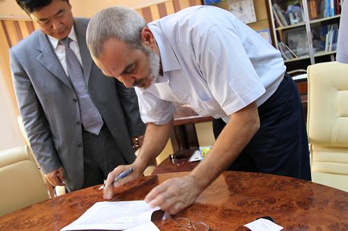8月20日,在利比亚班加西,利比亚“全国过渡委员会”人道主义救援委员会主席哈立德·穆罕默德在物资确认书上签字,中国驻埃及大使馆公使衔参赞马建春(左)出席了有关救援物资的会谈。新华社记者 王洪江 摄