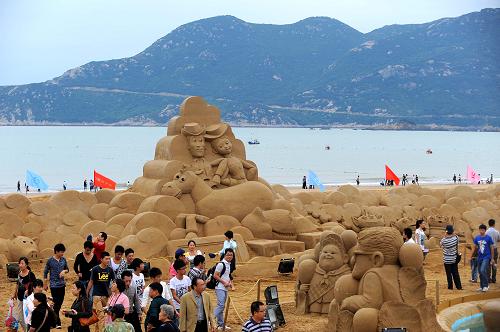 9月24日,游客在“沙雕迪士尼”主题公园内的《玩具总动员》动漫人物造型沙雕处游玩。新华社记者 徐昱 摄